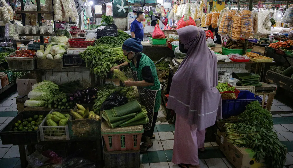 Pedagang sayuran melayani pembeli di kiosnya di Pasar Mede, Jakarta, Rabu (15/12/2021). Harga pangan menjelang Natal 2021 dan Tahun Baru 2022 (Nataru) mengalami kenaikan. (Liputan6.com/Faizal Fanani)