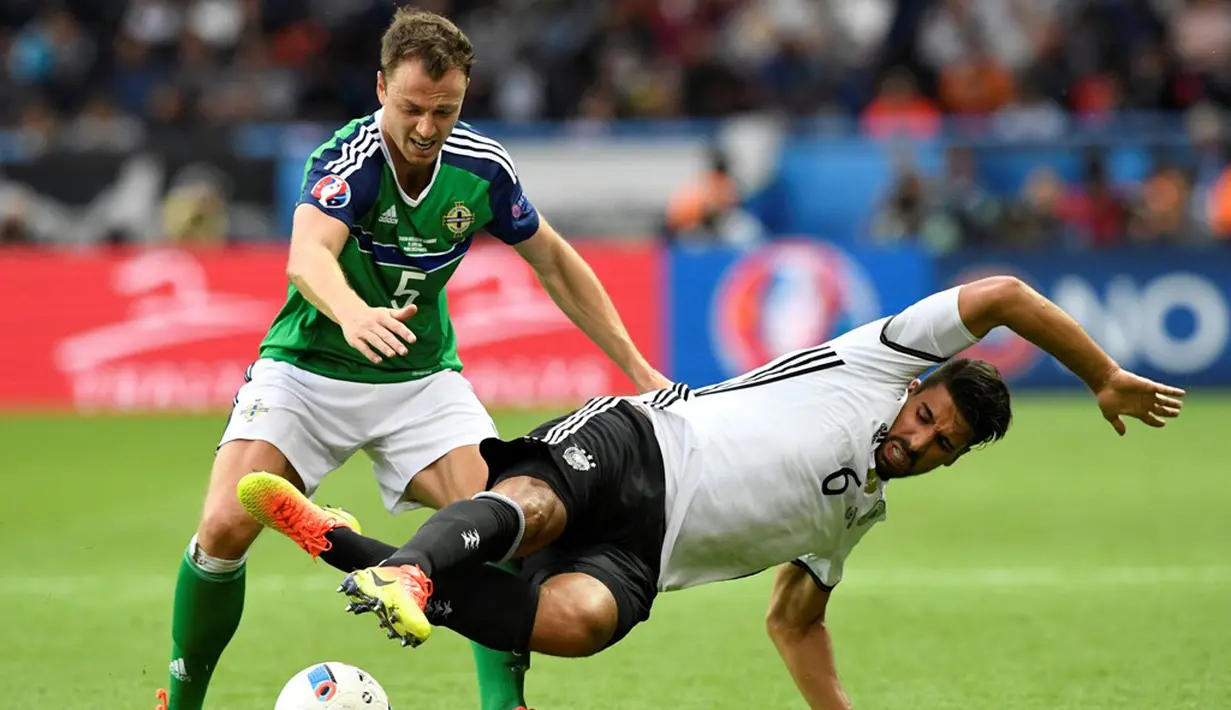  Pemain Jerman, Sami Khadira, berebut bola dengan pemain Irlandia Utara, Johnny Evans pada laga Grup C Piala Eropa 2016 di Parc des Princes, Paris, Selasa (21/6/2016). (AFP/Lionel Bonaventre)