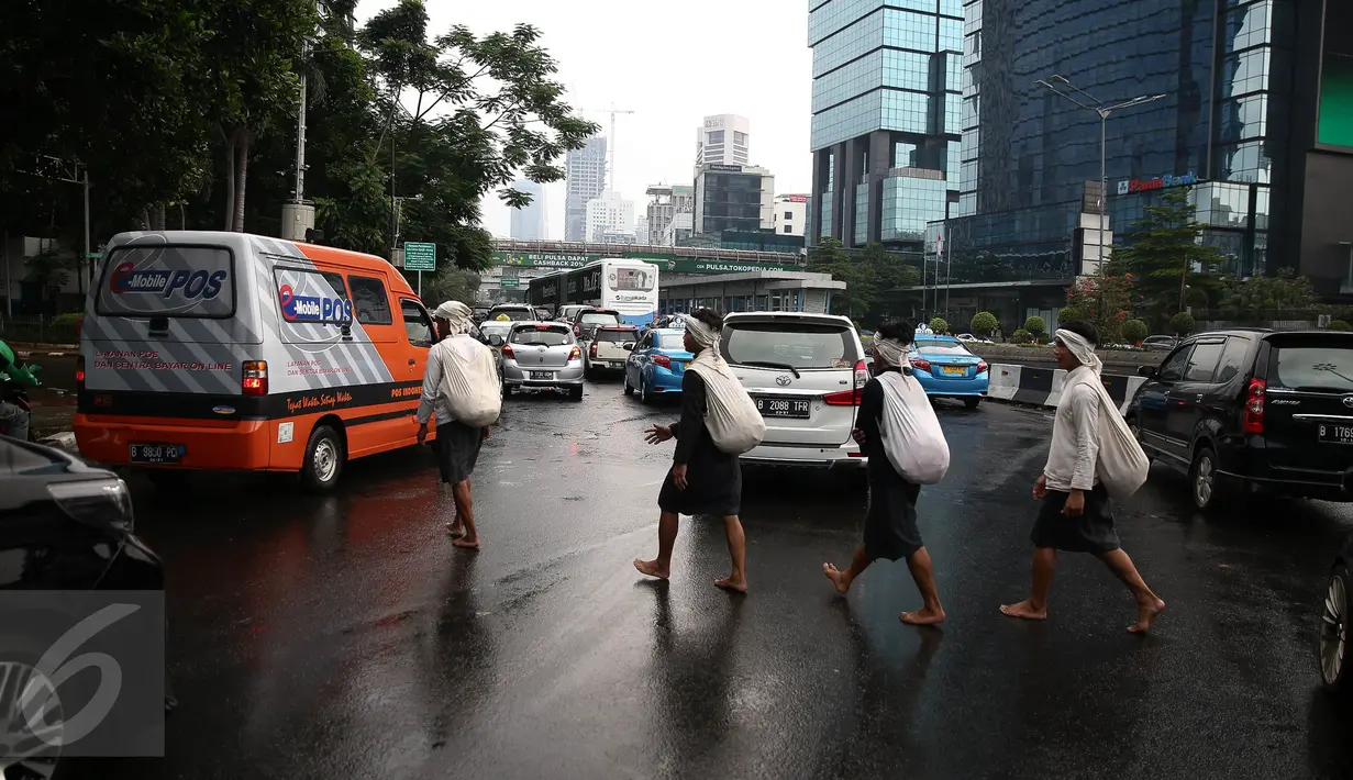 Empat warga Baduy menyeberang di kawasan Bundaran HI, Jakarta, Selasa (6/9). Biasanya warga Baduy menggembara ke Ibu Kota untuk menemui seseorang yang pernah datang ke desa mereka sekaligus menjual hasil kerajinan. (Liputan6.com/Faizal Fanani)