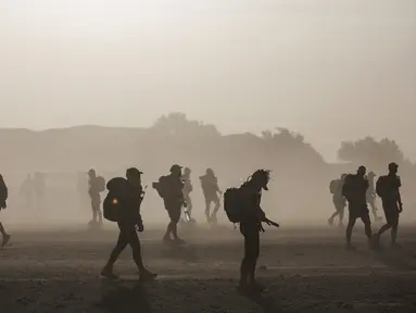 Sejumlah peserta berjalan saat terjadi badai pasir dalam kompetisi Marathon des Sables ke-33 di gurun Sahara, Maroko (13/4). Sekitar 1.000 peserta dari 50 negara ikut berkompetisi dalam Marathon des Sables ini. (AP Photo / Mosa'ab Elshamy)