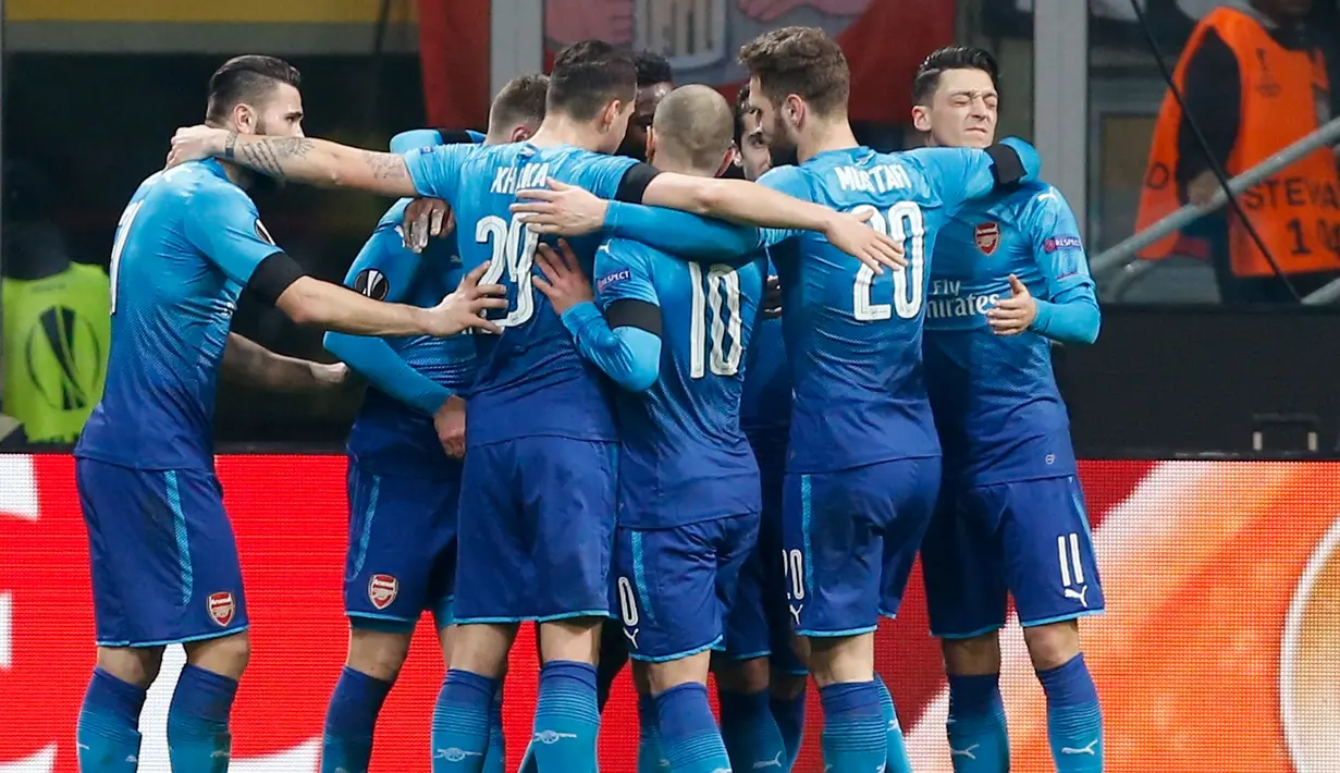 Pemain Arsenal Aaron Ramsey merayakan golnya bersama rekan setimnya saat melawan AC Milan pada pertandingan Liga Europa leg pertama di stadion San Siro Milan, Italia (8/3). Aaron Ramsey berhasil mencetak gol pada menit ke-45+4.(AP Photo / Antonio Calanni)