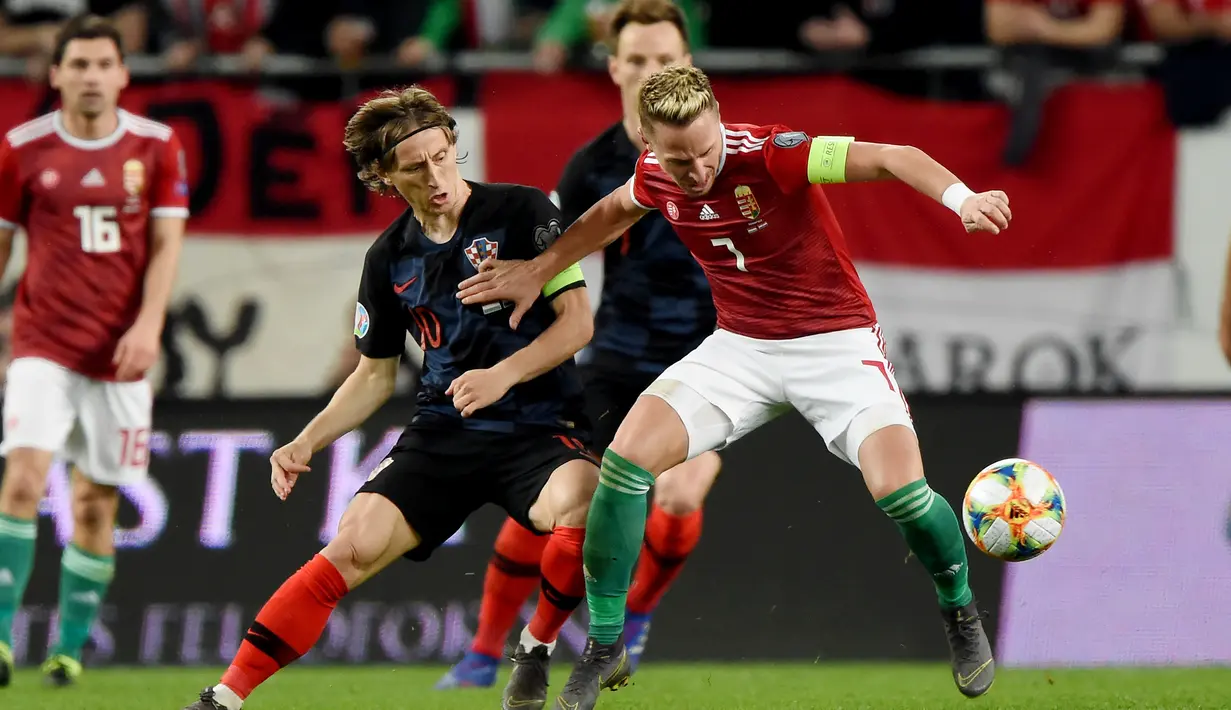 Pemain Hungaria, Balasz Dzsudzsak melewati Luka Modric pada laga kedua babak kualifikasi Piala Eropa 2020 Grup E yang berlangsung di Stadion Groupama Arena, Budapest, Senin (25/3). Kroasia kalah 1-2 kontra Hungaria. (AFP/Attila Kisbenedek)