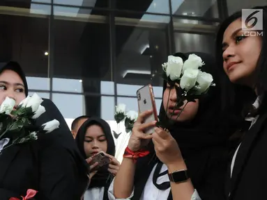 Sejumlah wanita membawa bunga mawar menyambut kedatangan penyidik senior KPK, Novel Baswedan saat masuk kerja kembali di gedung KPK, Jakarta, Jumat (27/7). Novel absen 16 bulan lantaran berobat matanya setelah diserang air keras. (Merdeka.com/Dwi Narwoko)