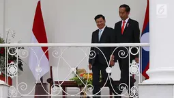 Presiden Jokowi dan PM Republik Demokratik Rakyat Laos Thongloun Sisoulith berjalan menuju beranda Istana Bogor, Kamis (12/8). Kunjungan kenegaraan PM Thongloun akan diakhiri dengan jamuan makan siang resmi. (Liputan6.com/Angga Yuniar)