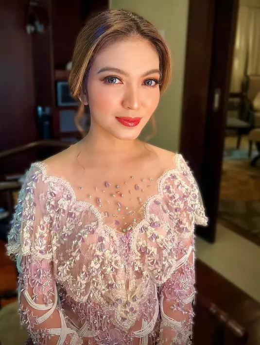 MUA Arik Wijayanti memoles wajah ibu Wali Kota Solo dengan riasan fresh mengenakan blush on coral, lipstik glossy merah, dengan highlighter di hidung. Serta eyeshadow coral dengan eyeliner tipis. [@arikcahyadewi]