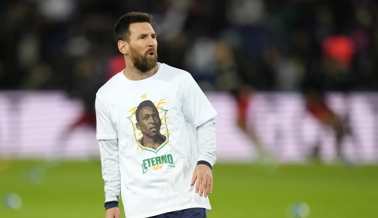 Penyerang Paris Saint-Germain (PSG) Lionel Messi mengenakan kaos dengan potret mendiang legenda sepak bola Brasil Pele sebelum lanjutan Liga Prancis 2022/2023 melawan Angers di Parc des Princes, Kamis (12/1/2023) dini hari WIB. Para pemain PSG memberikan tribute spesial untuk Edson Arantes do Nascimento atau lebih dikenal sebagai Pele. (AP Photo/Francois Mori)