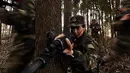 Tentara wanita China melakukan simualisi perang di tengah hutan saat melakukan latihan militer jelang Hari Perempuan Internasional di Hefei, China (6/4). (AFP)