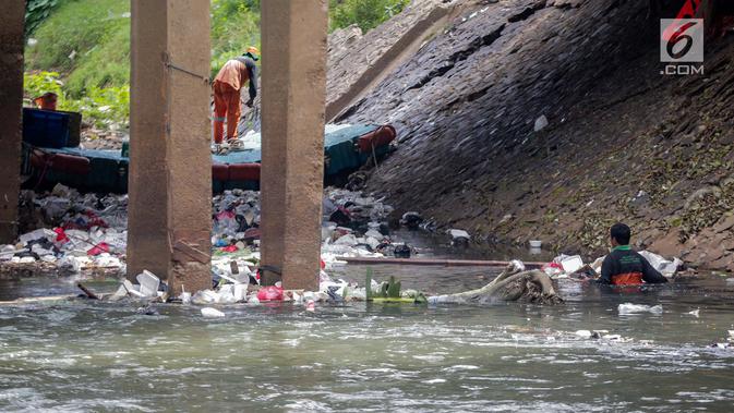 Petugas PPSU saat membersihkan tumpukan sampah yang tersangkut  di aliran anak kali Ciliwung, Jakarta, Senin (22/7/2019). Pembersihan sungai dari berbagai sampah tersebut dimaksudkan agar tidak ada penumpukan sampah dan sedimentasi saluran di sepanjang sungai. (Liputan6.com/Faizal Fanani)
