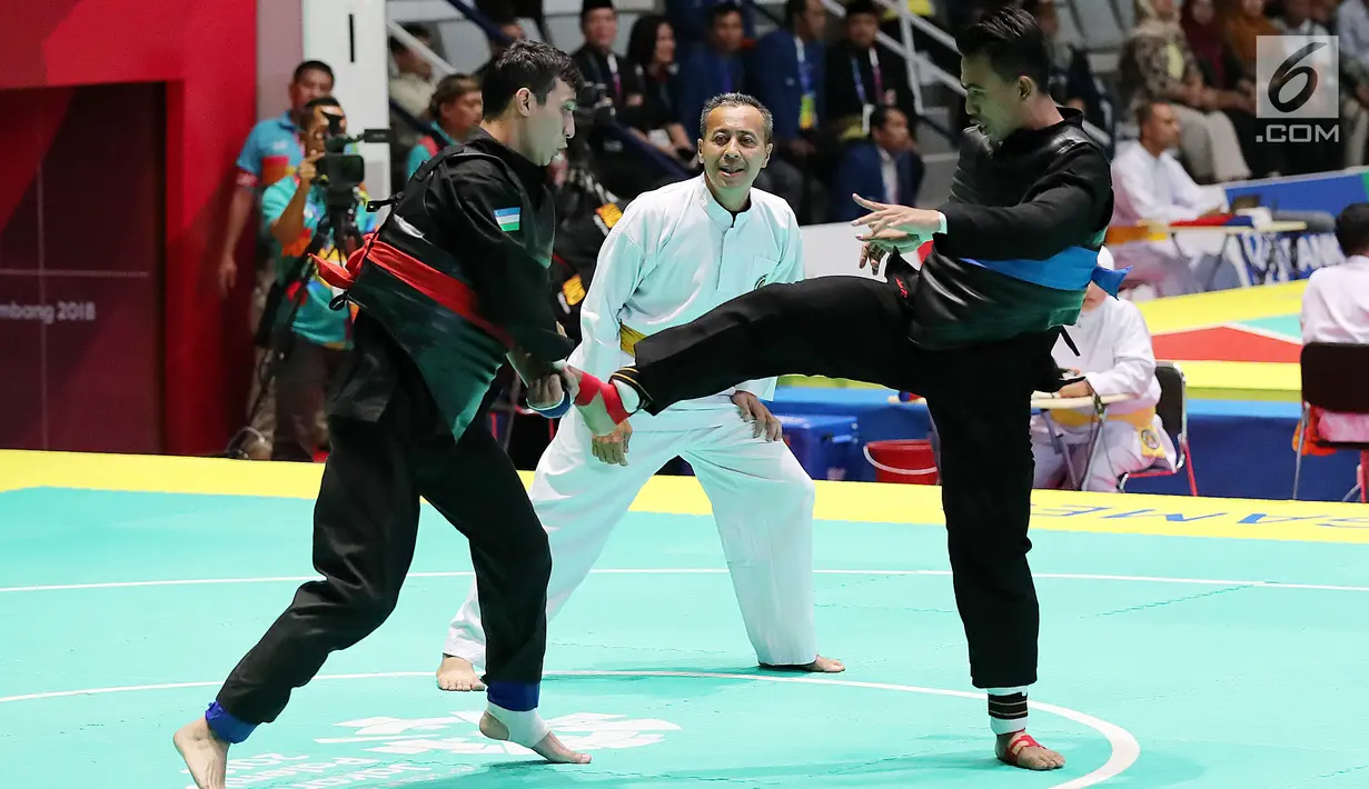 Pesilat Indonesia, Rusdana Amri saat bertarung melawan Pesilat Uzbekistan, Saidov Nurulla di Arena Pendopo Pencak Silat TMII, Jakarta, Kamis (23/8). Pesilat Rusdana Amri unggul dengan skor 5-0 dan masuk ke delapan besar. (Liputan6.com/Fery Pradolo)