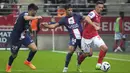 Pemain Paris Saint-Germain (PSG) Carlos Soler dan Juan Bernat menantang gelandang Reims Alexis Flips dalam pertandingan pekan ke-10 Liga Prancis di Stade Auguste-Delaune II, Minggu (9/10/2022) dini hari WIB. PSG harus bermain dengan sepuluh pemain setelah Sergio Ramos terkena akumulasi kartu kuning. (AP Photo/Michel Euler)