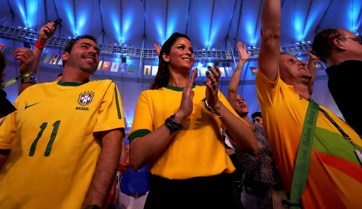 Seorang suporter wanita Brasil bertepuk tangan saat pembukaan Olimpiade 2016 di Rio de Janeiro, Brasil, (6/8). Sebanyak 80.000 penonton memenuhi Stadion Maracana untuk menyaksikan upacara pembukaan Olimpiade Rio 2016. (REUTERS/Damir Sagolj)