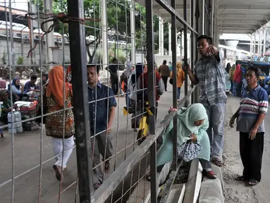 Pejalan kaki melintasi pagar pembatas di Jalan Jatibaru, Tanah Abang, Jakarta, Selasa (23/10). Belum selesainya pembangunan Skybridge Tanah Abang menyebabkan banyak PKL dan angkot mangkal di Jalan Jatibaru. (Merdeka.com/Iqbal Nugroho)