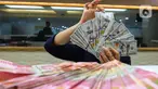Pegawai menghitung mata uang Rupiah dan Dolar AS di salah satu gerai penukaran uang di Jakarta, Rabu (26/6/2024). (Liputan6.com/Angga Yuniar)
