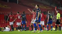 Wasit memberikan kartu merah kepada pemain Southampton, Alex Jankewitz, saat melawan Manchester United pada laga Liga Inggris di Stadion Old Trafford, Selasa (2/2/2021). Setan Merah menang dengan skor 9-0. (Laurence Griffiths/Pool via AP)