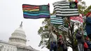 Sejumlah aktivis mengibarkan bendera yang bergambar daun ganja di dekat gedung Capitol di Washington (24/4). Mereka menggelar aksi tersebut untuk  mendukung legalisasi ganja. (AP Photo/Alex Brandon)