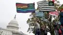 Sejumlah aktivis mengibarkan bendera yang bergambar daun ganja di dekat gedung Capitol di Washington (24/4). Mereka menggelar aksi tersebut untuk  mendukung legalisasi ganja. (AP Photo/Alex Brandon)