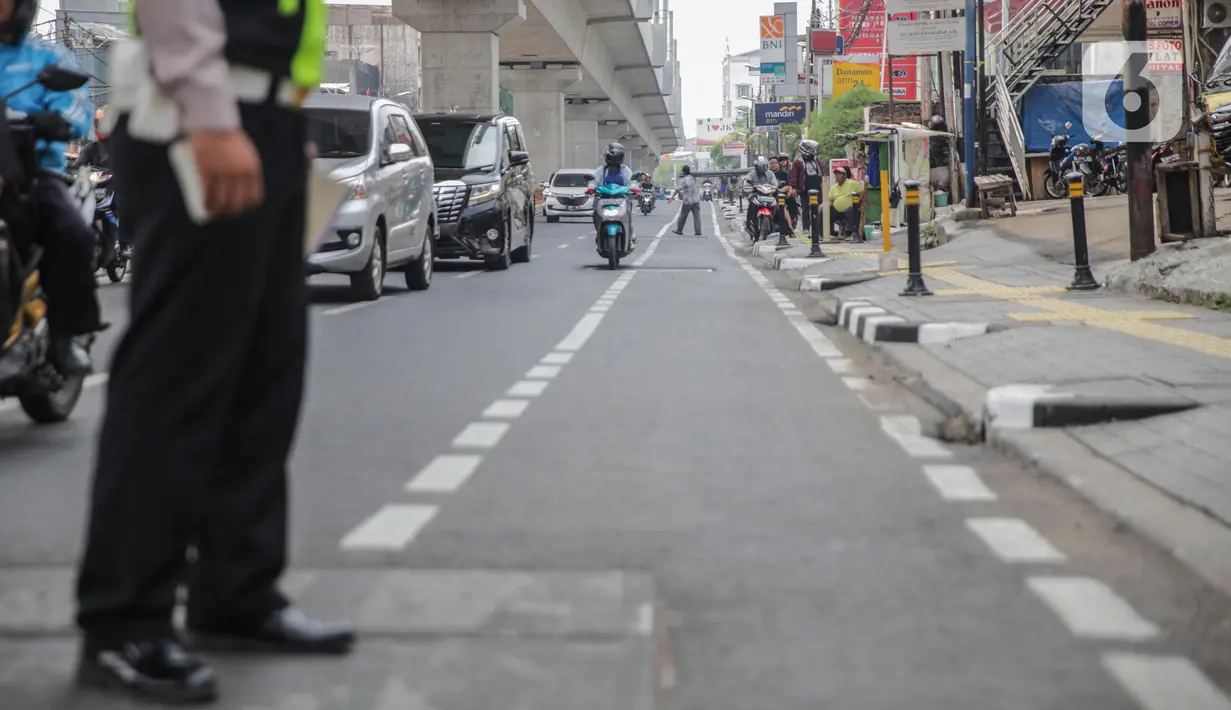 Petugas satlantas mensterilkan jalur sepeda di kawasan Blok A, Jakarta, Senin (25/11/2019). Mulai hari ini, polisi akan menilang para pengendara kendaraan bermotor yang nekat masuk dan melintas di jalur sepeda. (Liputan6.com/Faizal Fanani)