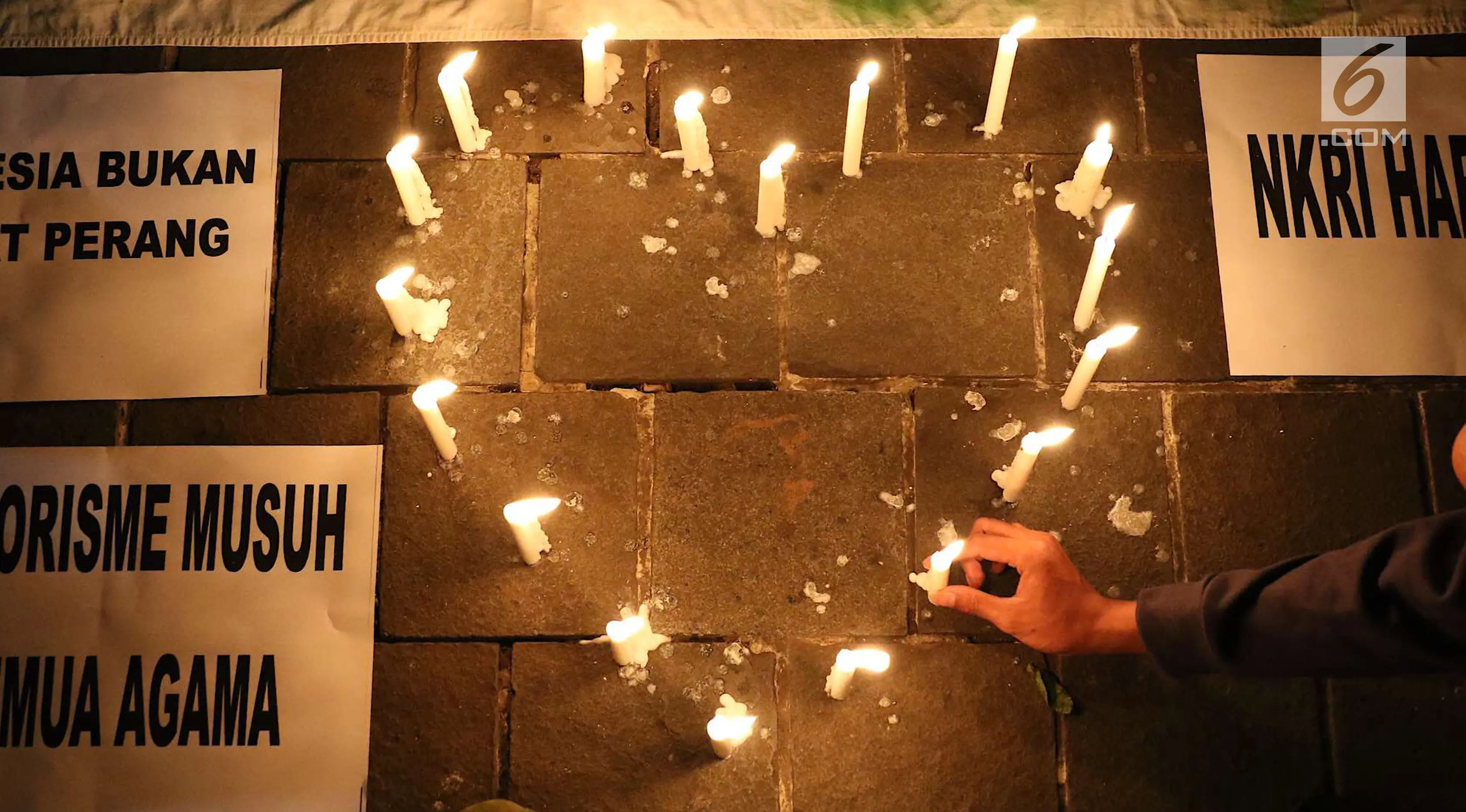 Lilin simbol cinta dinyalakan oleh gabungan suporter klub sepak bola dalam aksi solidaritas terkait tragedi teror bom di Surabaya dan Sidoarjo di Taman Suropati, Jakarta, Senin (14/5). (Liputan6.com/Immanuel Antonius)