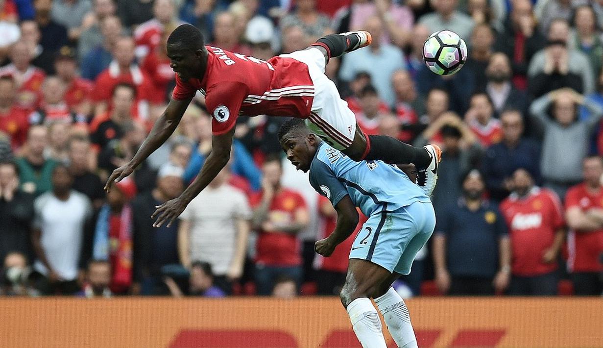 Pemain Manchester City, Kelechi Iheanacho, berduel dengan pemain Manchester United, Eric Bailly, dalam laga Premier League di Stadion Old Trafford, Sabtu (10/9/2016). Kelechi Iheanacho mencetak satu gol saat City menang atas MU. (AFP/Oli Scarff)