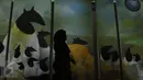 Pengunjung melintas di salah satu lukisan pada pameran “Pintu Belakang | Derau Jawa" di Galnas Indonesia, Jakarta (12/3). Karya disini lebih banyak menampilkan cerita-cerita tentang Parangtritis, Tamansari, dan Tengger. (Liputan6.com/Faisal R Syam)