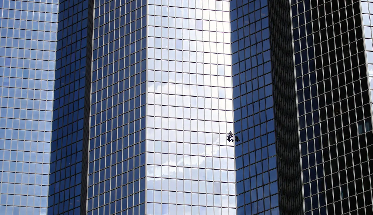 Alain Robert atau juga dikenal dengan nama 'Spiderman Prancis' memanjat gedung di pusat bisnis La Defense, Paris, Prancis, Rabu (14/3). Meski sudah menginjak usia 55 tahun, Alain masih melakukan hobi ekstremnya itu. (AP Photo/Francois Mori)
