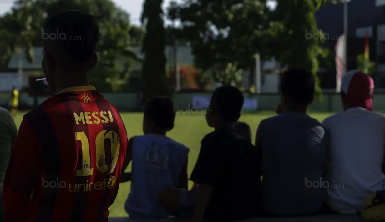 Sejumlah anak-anak tampak seru menyaksikan pertandingan pada laga Liga Remaja UC News di Lapangan Masariku Yonif 733, Ambon, Selasa (28/11/2017). Turnamen ini akan berlangsung hingga 1 Desember. (Bola.com/Peksi Cahyo)