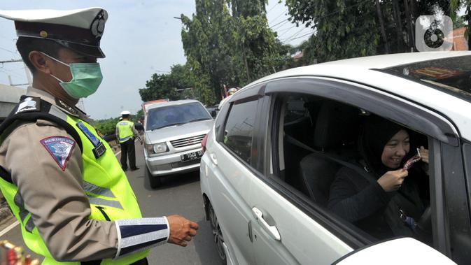 Petugas menyuruh pengemudi mengenakan masker saat kegiatan Check Point Pengawasan Pelaksaanaan PSPBB di kawasan Pasar Jumat, Jakarta selatan, Jumat (10/4/2020). Kegiatan gabungan Dishub dan Polda Metro Jaya merupakan Pergub Nomor 33 Tahun 2020 tentang Pelaksanaan PPSB. (merdeka.com/Arie Basuki)