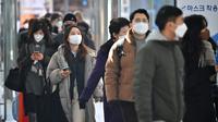 Orang-orang yang mengenakan masker berjalan melalui stasiun kereta api di Seoul, Korea Selatan, Jumat (18/2/2022). Kasus COVID-19 harian Korea Selatan melampaui 100 ribu untuk pertama kalinya. (Jung Yeon-je/AFP)