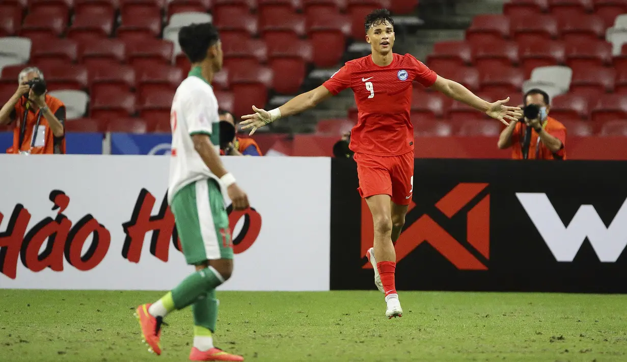 Pemain Singapura Ikhsan Fandi (kanan) melakukan selebrasi usai mencetak gol ke gawang Indonesia pada pertandingan leg pertama semifinal Piala AFF 2020 di National Stadium, Singapura, Rabu (22/12/2021). Pertandingan berakhir imbang 1-1. (AP Photo/Suhaimi Abdullah)