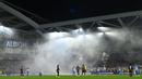 Asap membubung di atas lapangan saat Marseille menunggu untuk memulai kembali pertandingan pada laga terakhir Grup B Liga Europa 2023/2024 melawan Brighton di American Express Community Stadium, Brighton, Inggris, Jumat (15/12/2023). (AFP/Glyn Kirk)