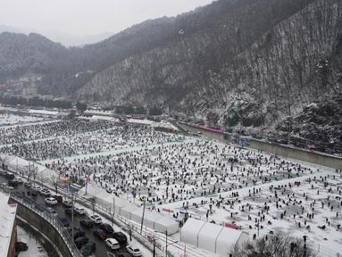 Para peserta memancing ikan trout melalui lubang yang mereka buat di atas sungai beku di Hwacheon, Korea Selatan, Sabtu (7/1/2023). Kontes ini merupakan bagian dari festival es tahunan yang menarik lebih dari satu juta pengunjung setiap tahun. (AP Photo/Ahn Young-joon)