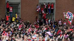 Warga Madrid tumpah ke jalan saat menyambut konvoi Atletico Madrid merayakan gelar Liga Europa di Madrid, Jumat (18/5/2018). Kota Madrid menjadi merah saat perayaan gelar juara Atletico. (AFP/Oscar Del Pozo)