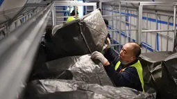 Seorang pekerja memasukkan paket ke kereta peluru Fuxing di Stasiun Kereta Barat Beijing di Beijing, ibu kota China (1/11/2020). Otoritas perkeretaapian China meluncurkan layanan khusus pada Minggu (1/11), yang akan berlangsung hingga 20 November. (Xinhua/Zhang Chenlin)