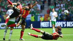 Gelandang Belgia, Moussa Dembele, berebut bola dengan penyerang Irlandia, Shane Long, pada laga Grup E Piala Eropa 2016. Hasil ini membuat Belgia berada pada posisi dua klasemen sementara di bawah Italia. (AFP/Emmanuel Dunand)