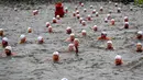 Orang-orang mengambil bagian dalam kompetisi berenang Natal tahunan di sungai Vltava, ibu kota Republik ceko, Praha, Rabu (26/12). Dalam menyemarakkan Natal, para peserta mengikuti lomba renang di sungai bersuhu dingin. (AP/Petr David Josek)