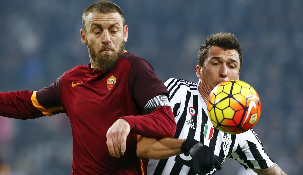 Penyerang Juventus, Mario Mandzukic (kanan) berebut bola dengan gelandang AS Roma, Daniele De Rossi pada lanjutan liga serie A Italia di Juventus Stadium, Turin (24/1/2016). Juventus menang dengan skor 1-0. (REUTERS/Stefano Rellandini)