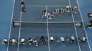 Ball boy mengeringkan Rod Laver Arena saat hujan berhenti selama pertandingan tunggal putaran pertama antara Roger Federer dari Swiss dan Steve Johnson dari Amerika Serikat di kejuaraan tenis Australia Terbuka di Melbourne, Australia, Senin (20/1/2020). (AP Foto/Lee Jin-man)