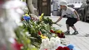 Anak kecil meletakkan buket bunga ucapan dukacita untuk para korban jatuhnya pesawat Malaysia Airlines MH17 di depan Kedutaan Besar Belanda di Moskow, Jumat (18/7/14). (REUTERS/Sergei Karpukhin)