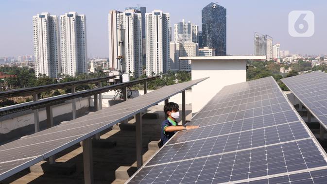 Pekerja melakukan pengecekan panel surya di atas gedung di kawasan Jakarta, Senin (31/8/2020). Pemerintah tengah menyiapkan peraturan presiden terkait energi baru terbarukan dan konservasi energi agar target 23 persen bauran energi di Indonesia bisa tercapai pada 2045. (Liputan6.com/Angga Yuniar)