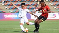 Pemain Timnas Indonesia U-22, Witan Sulaiman (kiri),&nbsp;menendang bola dibayangi pemain Timor Leste, Cristevao Moniz Fernandes pada pertandingan ketiga Grup A SEA Games 2023 yang berlangsung di Olympic Stadium, Phnom Penh, Kamboja, Minggu (7/5/2023). (Bola.com/Abdul Aziz)