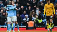 Striker Manchester City, Erling Haaland, memeluk rekan setimnya, Kevin de Bruyne, setelah mencetak gol ke gawang Wolverhampton Wanderers dalam laga pekan ke-21 Premier League, Minggu (22/1/2023). Man City menang 3-0 berkat hattrick Haaland. (PAUL ELLIS / AFP)