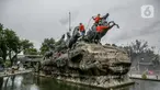 Aktivitas pembersihan dan perawatan patung kuda Arjuna Wijaya di Jalan Medan Merdeka, Jakarta, Rabu (27/1/2021). Patung yang dibangun sejak 1987 karya pematung Nyoman Nuarta tersebut dibersihkan dan ditata kembali untuk memperindah kota. (Liputan6.com/Faizal Fanani)