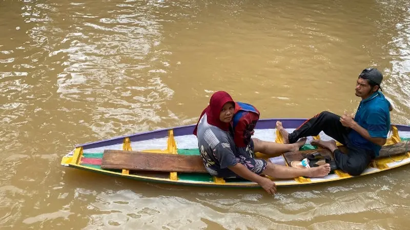 Warga di Rokan Hulu mengungsi pakai perahu karena rumahnya terendam banjir.