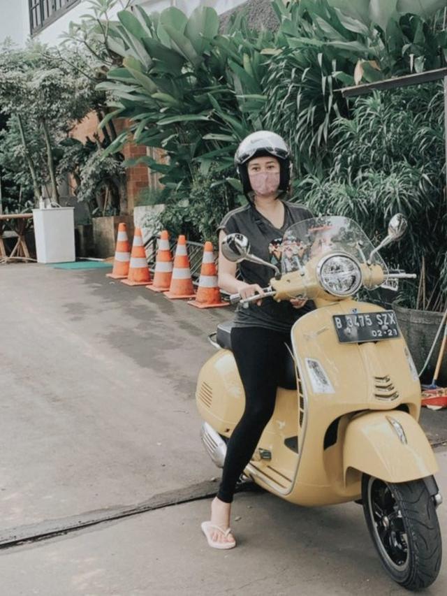 Aura Kasih saat menaiki motor Vespa