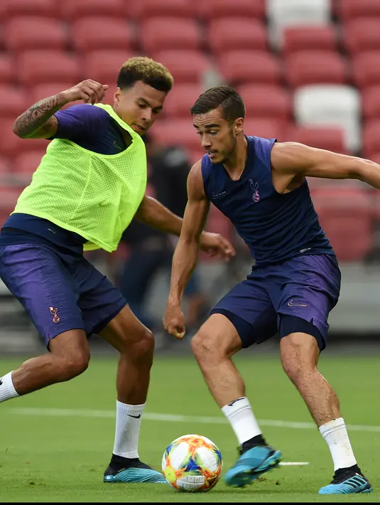 Gelandang Tottenham Hotuspur, Dle Alli (kiri) berusaha merebut bola rekannya Harry Winks selama latihan di Singapura  (19/7/2019). Tottenham akan bertanding melawan Juventus pada International Champions Cup 2019 di National Stadium, Singapura. (AFP Photo/Roslan Rahman)