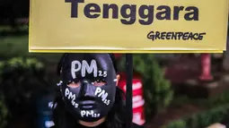 Aktivis Greenpeace melakukan aksi teatrikal terkait kualitas udara Jakarta di Kementerian Lingkungan Hidup, Selasa (5/3). Greenpeace mengungkapkan Jakarta menjadi peringkat satu  di Asia Tenggara untuk kualitas udara terburuk. (Liputan6.com/Faizal Fanani)