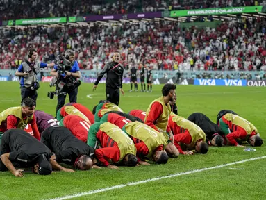 Para pemain Maroko merayakan kemenangan atas Spanyol  pada babak 16 besar Piala Dunia 2022 di Education City Stadium, Al Rayyan, Rabu (6/12/2022) dini hari WIB. Para pemain Timnas Maroko sujud syukur setelah menyingkirkan  Spanyol melalui adu tendangan penalti. (AP Photo/Martin Meissner)