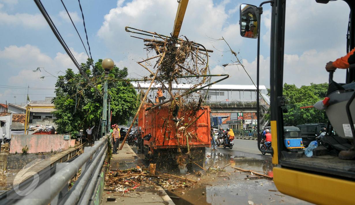 Alat berat memindahkan sampah ke truk pengangkut sampah di jembatan Kampung Melayu, Jakarta, Minggu (3/4/2016). Akibat luapan Ciliwung, tumpukan sampah menyangkut di jembatan Kampung Melayu. (Liputan6.com/Yoppy Renato)