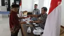 Warga menerima surat suara untuk mencoblos pada Pilkada Serentak 2018 di TPS 2 yang berada di dalam Museum Juang Taruna, Tangerang, Rabu (27/6). Warga Kota Tangerang menyalurkan suaranya dalam Pemilihan Walikota tahun ini. (Liputan6.com/Angga Yuniar)