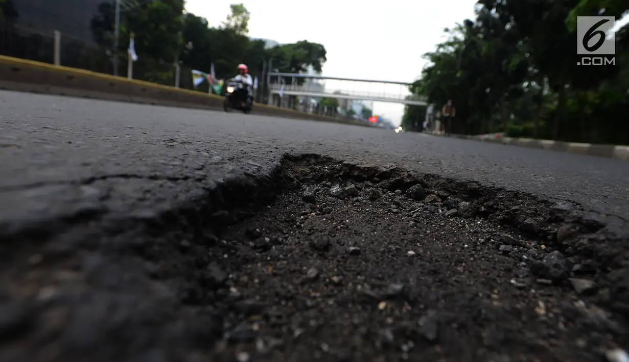 Kondisi jalan berlubang di Jalan Gunung Sahari, Jakarta, Selasa (9/4). Meskipun sudah dilakukan penambalan, jalan raya tersebut sering rusak akibat beban kendaraan yang melintas di atasnya dan intensitas hujan yang belakangan ini cukup tinggi. (merdeka.com/Imam Buhori)